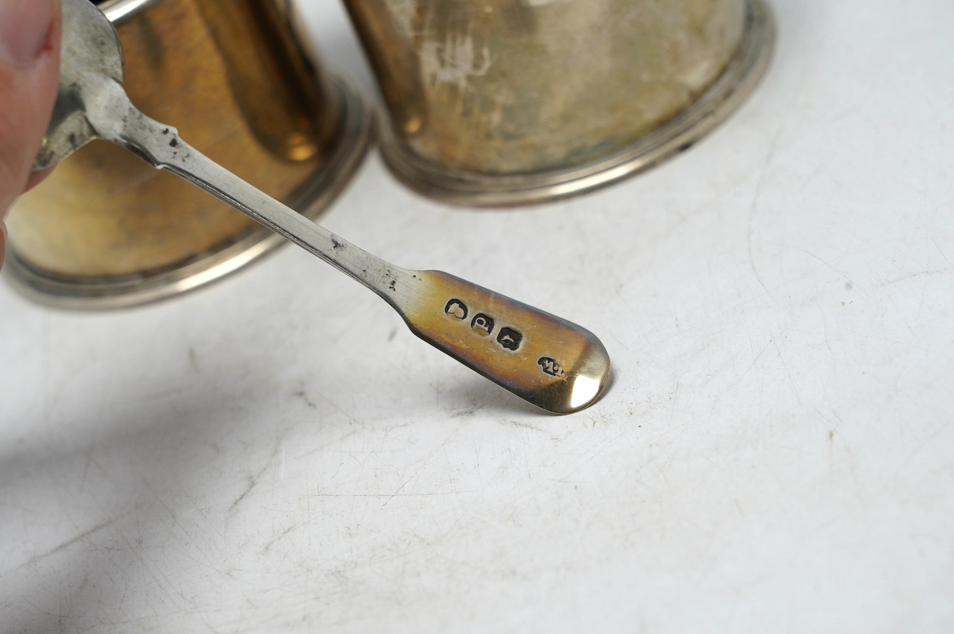 A pair of George V silver drum mustards, by Harman & Co, London 1929, 70mm, one with associated spoon. Condition - fair